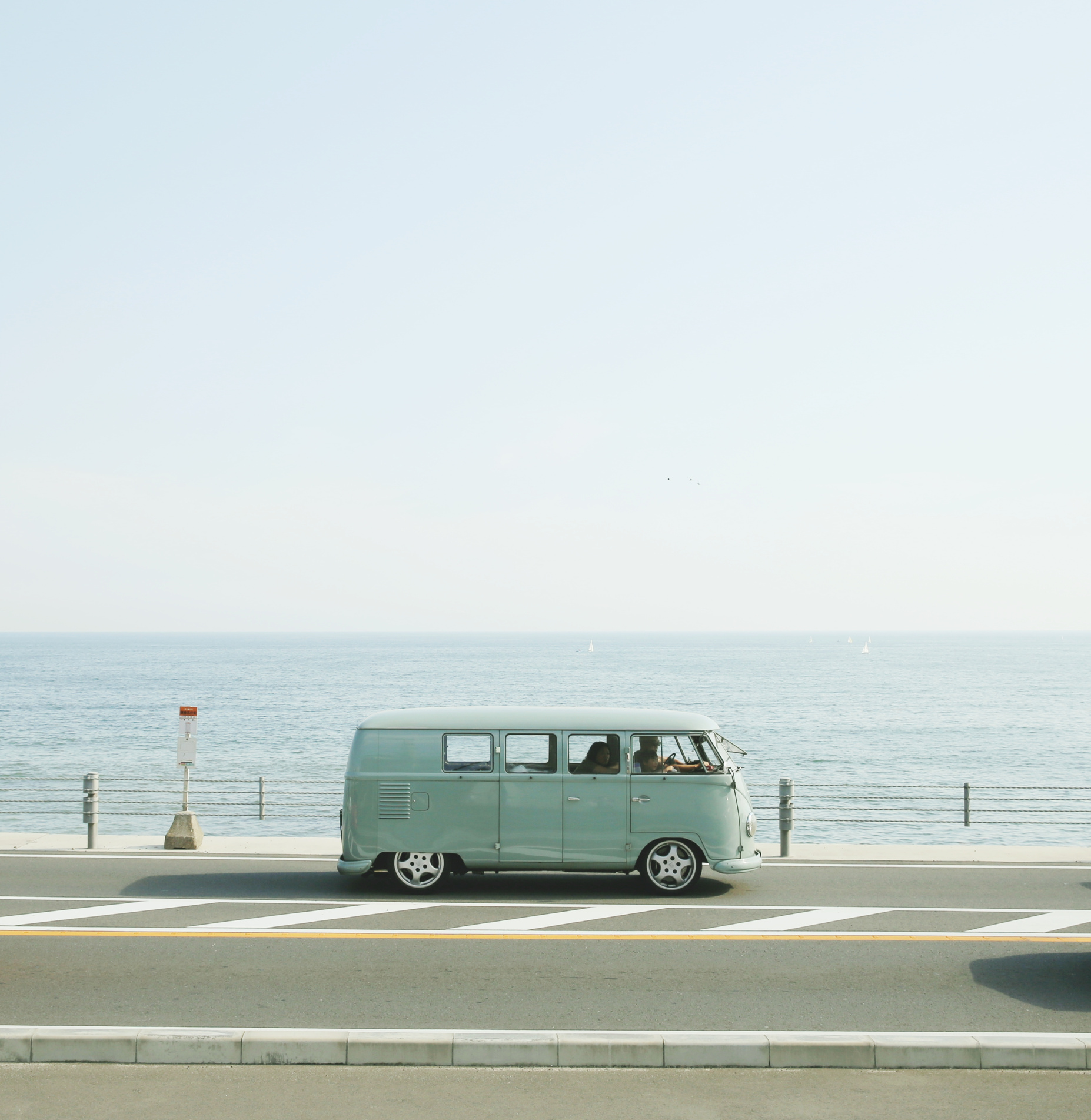 Van Parked Beside the Road Near Handrail and Ocean